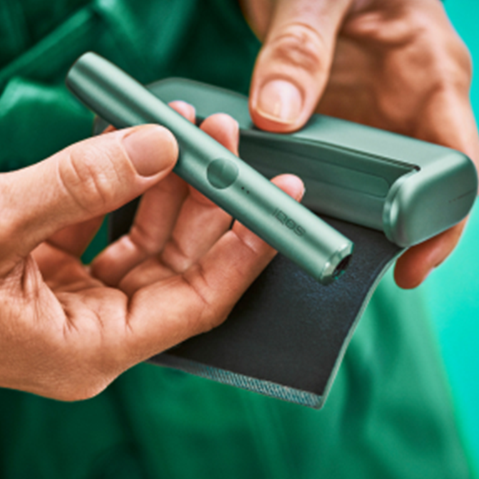 An IQOS ILUMA PRIME device in the hands of an IQOS user.