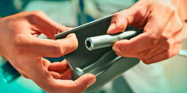 IQOS ILUMA Prime user holding a device and case.
