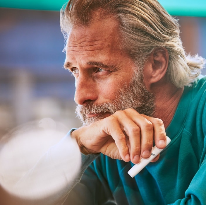 Man with white IQOS holder in his hand