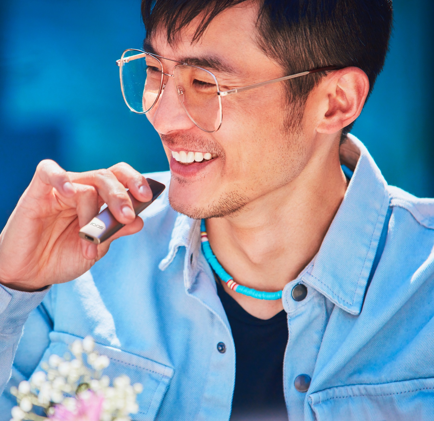 Man in blue jumper unboxing a new IQOS device