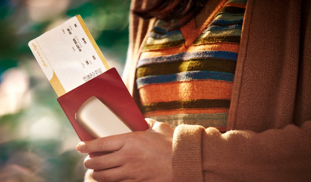 Girl with a flight ticket, an IQOS device and a passport in her hand