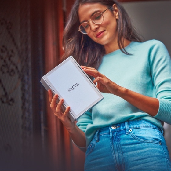 Woman looking at IQOS packaging